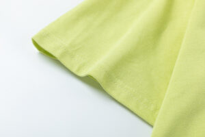 Close-up view of the premium soft-touch cotton fabric texture on a yellow Hellstar Studios short sleeve T-shirt.