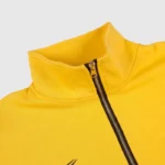 Close-up view of the yellow Hellstar Studios zipper sweater showing the high collar and metal zipper detail.