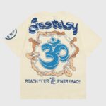 Hellstar Studios beige yoga tee back print with large blue Om, intertwined yoga figures and "Reach Your Inner Peace" slogan