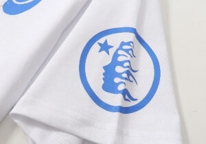 Close-up view of the blue graphic print detail on a white Hellstar Studios Yoga T-shirt featuring a spiritual design.