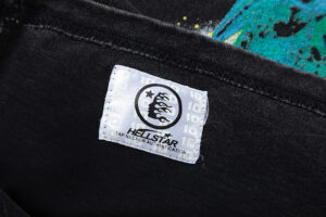 Close-up of the Hellstar The Future Iconic Tee Shirt authentication tag on a black vintage washed cotton garment.
