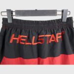 Waist detail of the black Hellstar Thriller track pants featuring a bold red embroidered logo and elastic waistband.