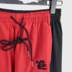 Detailed view of the Hellstar Thriller red track pants featuring an elastic drawstring waistband and embroidered logo.