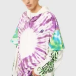A model wearing the Hellstar tie-dye zip-up hoodie, featuring a vibrant purple and green pattern with custom graphics.