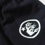 Close-up view of the Hellstar Uniform Sweatpant featuring a detailed graphic logo print on soft black fleece fabric.