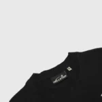 Premium Hellstar black unisex t-shirt showing the interior neck tag detail and branded streetwear aesthetic.