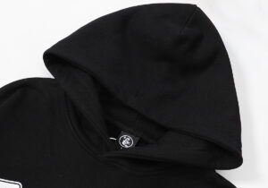 Close-up view of the hood on a black Hellstar Victory Capsule 6 streetwear hoodie with a small branded neck tag.