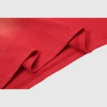 Close-up view of the premium red cotton fabric texture from a Hellstar Warm Up T-shirt with vintage washed effect.