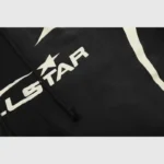 Close-up view of the white Hellstar Studios graphic logo print on black vintage washed fleece warm up shorts.