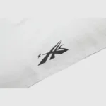 A close-up view of the black graphic logo on a white 100% cotton Hellstar Warm Up T-Shirt with a vintage wash effect.