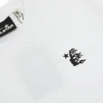 Hellstar white unisex t-shirt closeup showing small black flame-head logo and star on soft cotton tee