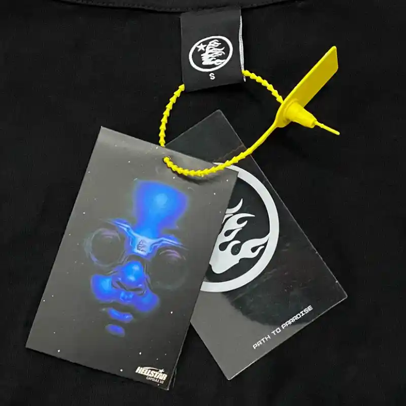 Hellstar Worship Hands T-Shirt featuring authentic branding tags with the iconic Hellstar logo and blue graphic design.