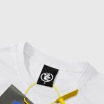 Close-up view of the Hellstar brand logo on the neckline tag of the official WWE Heavyweight Championship T-Shirt.