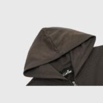Close up view of the hood and branded interior tag on a premium dark brown Hellstar zip-up streetwear hoodie.