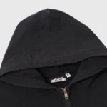 Close-up view of a black Hellstar zip-up hoodie featuring the brand neck label and drawstring hood design details.