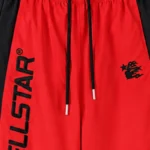 Close-up view of Hellstar Thriller red sweatpants featuring black side panels and the iconic Hellstar logo branding.