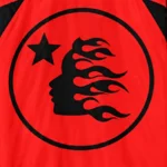 Close-up of the Hellstar Thriller red sweatpants featuring a black circular logo with a flaming head and a star icon.